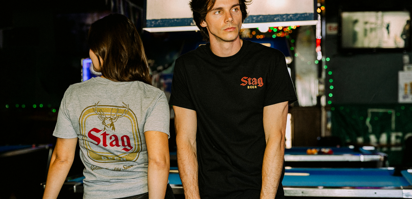 Two people standing behind a pool table in a casual setting