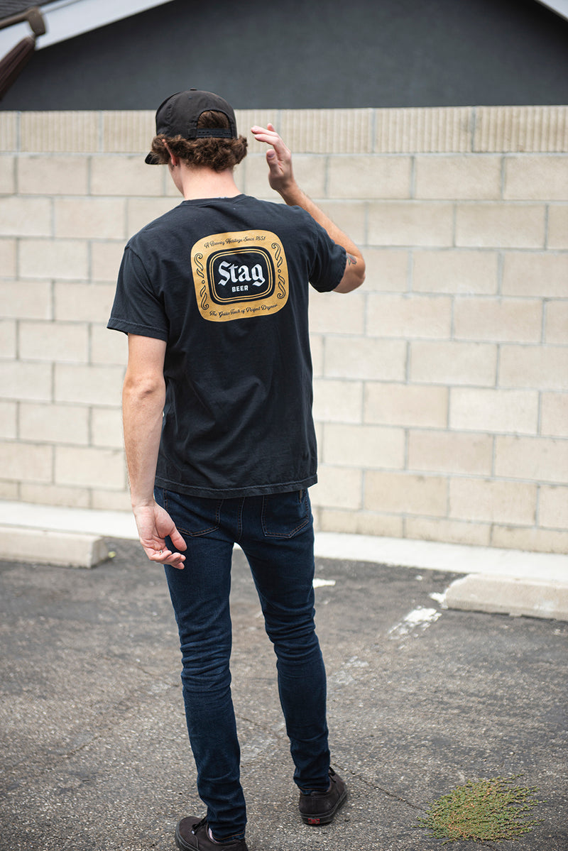 back of man wearing BADGE TEE - BLACK - Stag Beer 