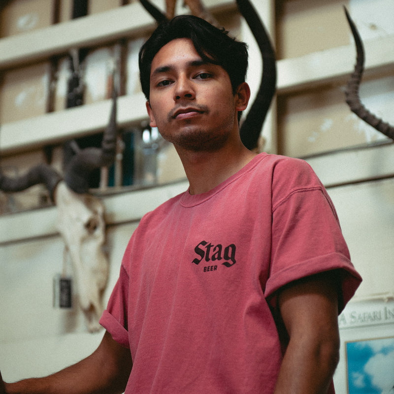 front of muted red t-shirt with Stag Beer in Black on the left chest on a male model